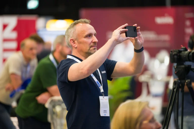 Delegate taking a photograph of the event at the 2026 Sustainable Food Factory and Food+Beverage Engineering event.