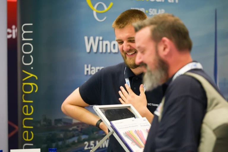Exhibitors discussing information on a tablet at the 2026 Sustainable Food Factory and Food+Beverage Engineering event.