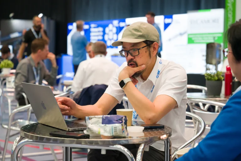 Visitor working on a laptop at a cafe table at the 2026 Sustainable Food Factory and Food+Beverage Engineering event.